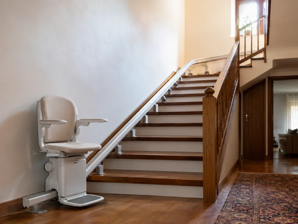 Sillas salvaescaleras en Alcobendas: raíl atornillado a los peldaños de la escalera de una casa, con la silla aparcada abajo